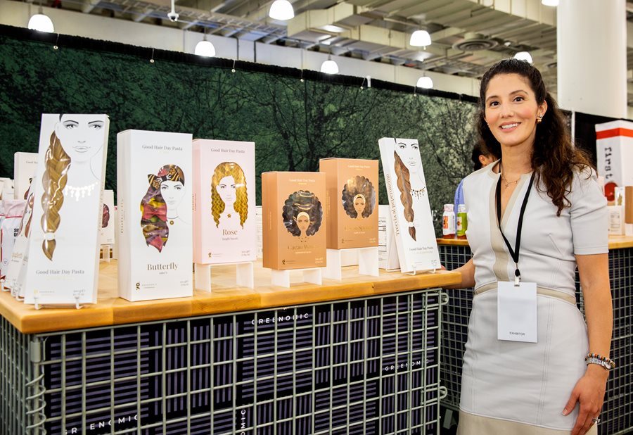 Exhibitor at the Fancy Food Show standing by her booth