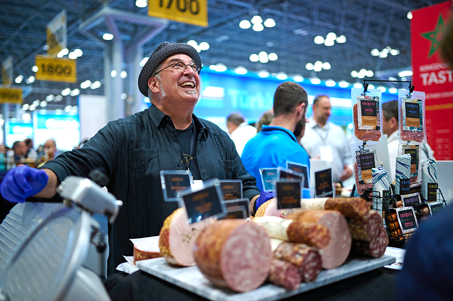 Member carving meat and smiling at the Fancy Food Show