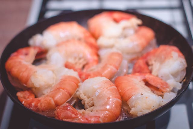 A dozen shrimp in a bowl on a table.