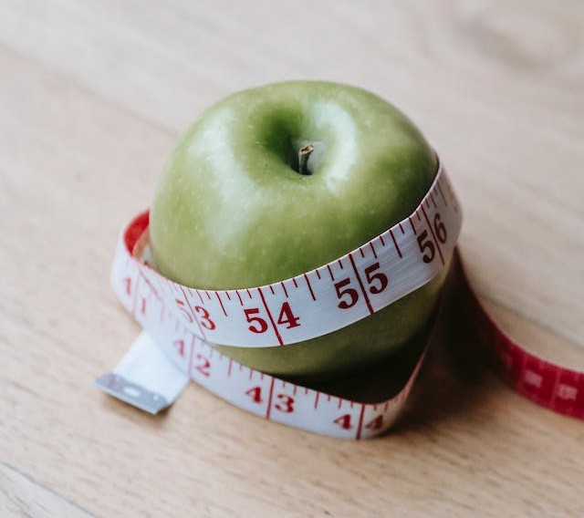 Measuring tape wrapped around apple